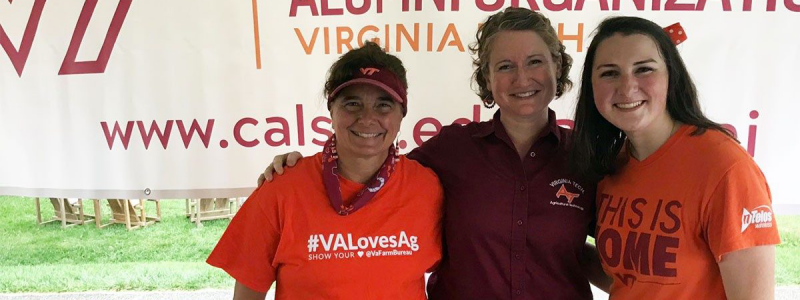 Image of three smiling female alumni in Virginia Tech shirts.