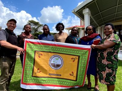 Dr. Eric Bendfeldt presenting a khanga with four soil health principles translated into Swahili as an educational communication method to Dr. Miriam Kyule (second from left) and her Agricultural Education and Extension colleagues at Egerton University in Njoro, Kenya.