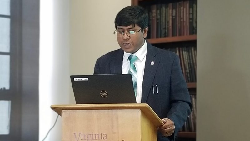 Dr. Farouque speaking at a podium