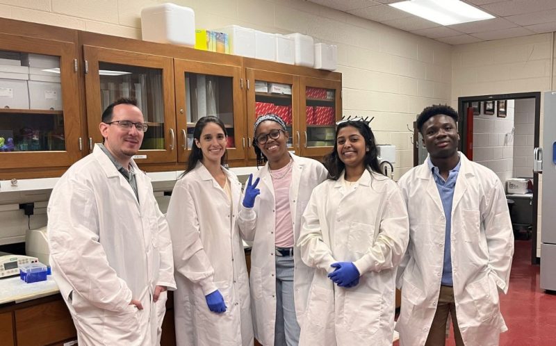 A group of smiling people in lab coats.