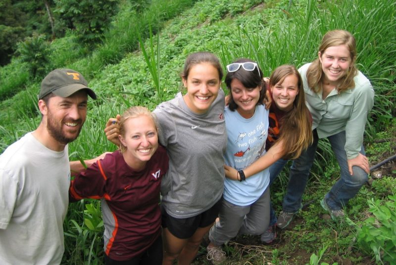 Six Virginia Tech students pose for a photo on a grassy hillside in Ecuador.