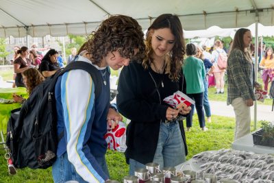 Two students grabbing merch 