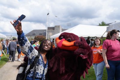Student taking photo with the Hokie Bird