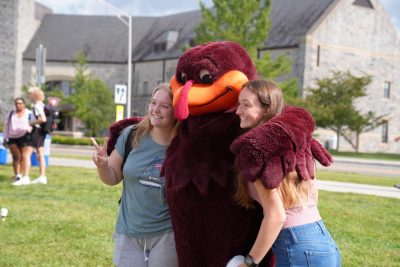 Students taking photo with the Hokie Bird