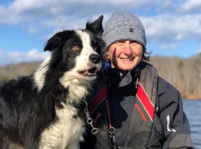 A dog and woman in front of a river